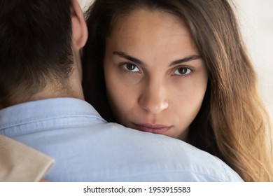 Close up portrait of young Latino woman hug husband feel unsure doubtful about relationships. Millennial female embrace man lover look at camera thinking. Cheating, relation problem concept. - Shutterstock ID 1953915583