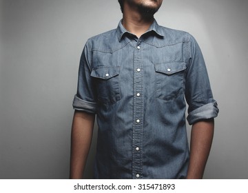 Close up Portrait of a  young man in a blue jeans shirt on the background of white