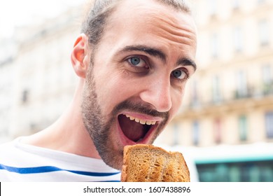 Close Up Portrait Of Young Man Eating Sandwich Outside In City