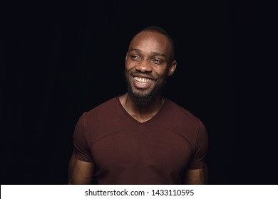 Close up portrait of young man isolated on black studio background. Photoshot of real emotions of male model. Crying throught laughting and smiling. Facial expression, human emotions concept.