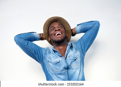 Close Up Portrait Of A Young Man Laughing With Hands Behind Head On White Background