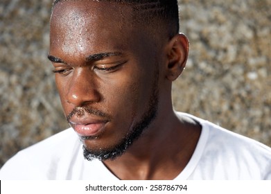 Close Up Portrait Of A Young Man Looking Away With Sweat Dripping Down Face