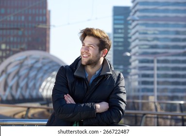 Close Up Portrait Of A Young Man Smiling With Winter Jacket In The City