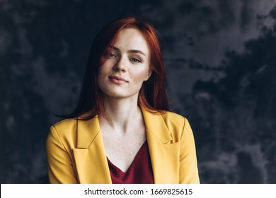 Close up portrait of a young natural beautiful girl with freckles on grey background. Natural beauty, caucasian freckled girl concept