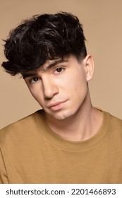 close up portrait of young non-binary Caucasian man in his 20s on neutral background