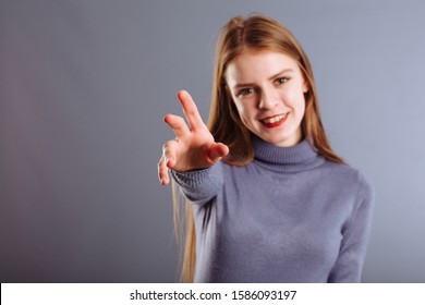 Close Up Portrait Of Young Thai Woman Looking At Camera With Fierce Looking, Reaching Hand To Camera..