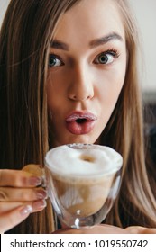 Close Portrait Of A Young Woman Drinking Coffee In Bed With Milk Moustache