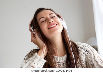 Close up portrait of young woman listening to music with eyes closed - Shutterstock ID 1090371494