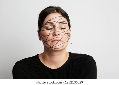 Close up portrait of young woman on white background. Wearing black thread imitated a skin fatigue. - Shutterstock ID 1252136329