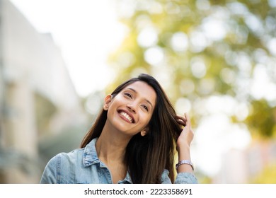 Close up portrait young woman smiling with hand in hair - Shutterstock ID 2223358691