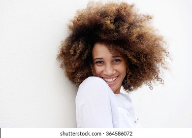 Close Up Portrait Of A Young Woman Smiling With Afro Hair Against White Background 