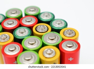 Close up of positive ends batteries, selective focus. Used battery for recycling. Hazardous garbage concept. Different colours of batteries on white background. - Shutterstock ID 2213053541
