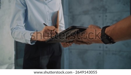 Close Up of Postman Delivering Small Parcel for Addressee in Office, Getting Client's Signature on Digital Tablet. Businesswoman Taking Padded Envelope with Online Shopping Order. Delivery Service.