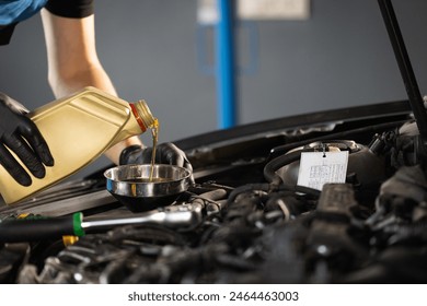 Close up of pouring fresh new motor oil into car's engine. New engine oil is poured into the engine. replacement of technical fluids of the car. - Powered by Shutterstock