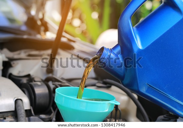 Close up of Pouring fresh oil to car engine in\
auto repair service, Change\
oil