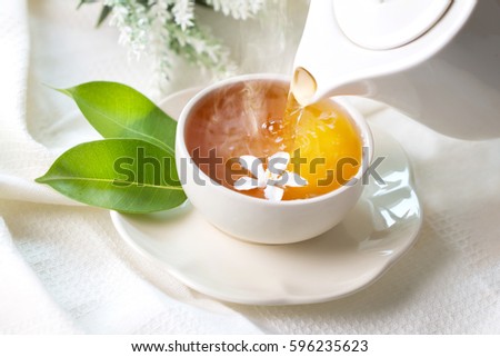 Close up pouring hot jasmine tea in a white tea cup ,  Tea ceremony time concept