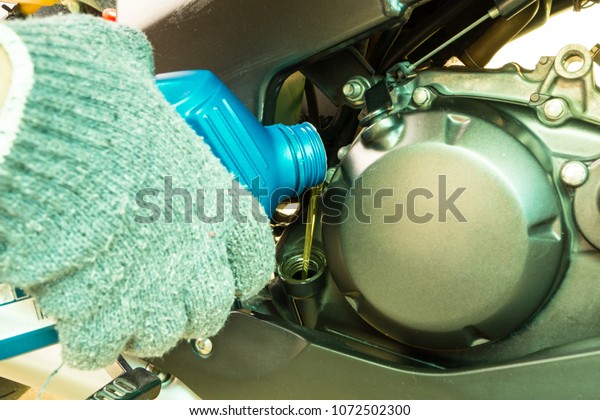 Close up of\
pouring new oil to Motorcycles\
engine.