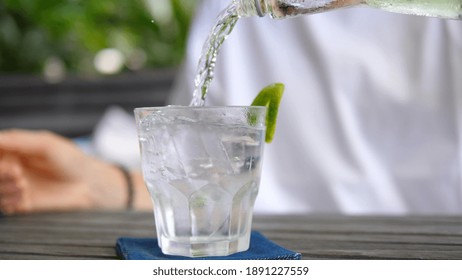 Close up of pouring water into a glass with ice cubes. Healthy lifestyle concept - Powered by Shutterstock