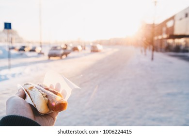 Close Up Pov Of Man Holding Hot Dog During Winter In Urban Street
