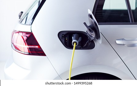 Close Up Of Power Cable Charging Environmentally Friendly Zero Emission Electric Car In Garage