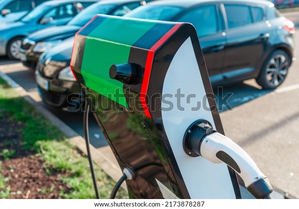 Close up power cord\
for electric car. Green station.Power supply for electric car\
battery charging.Blurred car in the background.Selective\
focus.Closeup.