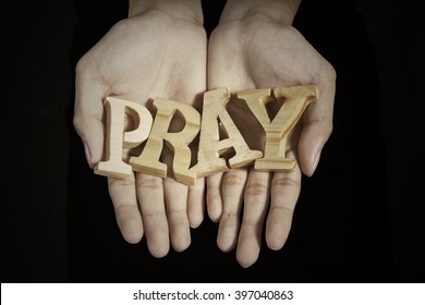 Close Up Of Prayer Hands Showing A Word Of Pray In Dark Background