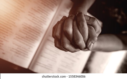 Close up prayer's hands folded pray in church, Pastor pray to God with BIBLE, top view with blank copy space  - Shutterstock ID 1558346006