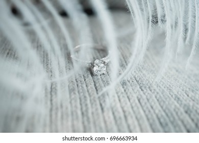 Close up precious round shape diamond ring on gray scarf background. (soft and selective focus)