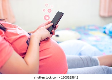 Close Up Pregnant Mother Laying Down Relaxing Using Mobile Phone Device Smart Technology, Contact Interacting Touching Screen Browsing Internet Playing, Researching Becoming Mom Motherhood Parenthood