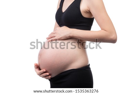 Close Up Of Pregnant Woman Holding Belly. Belly of pregnant woman with hands. Maternity concept.