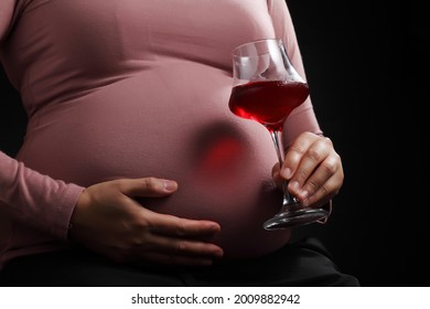 Close Up Pregnant Woman Holding Red Wine In Glass Isolated On Black Background