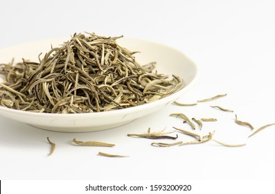 Close up of premium quality dried white tea leaves in small dish.