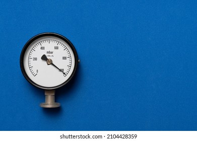 close up of pressure gauge on blue table background, engineering equipment concept - Shutterstock ID 2104428359