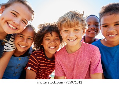 Close up of pre-teen friends in a park smiling to camera