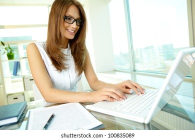 Close up of a pretty female businessperson typing with a smile - Powered by Shutterstock