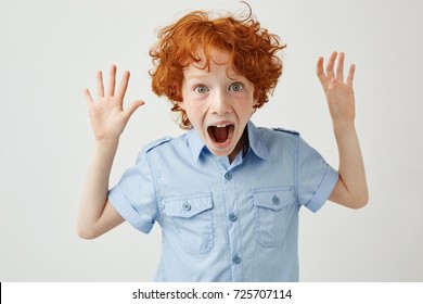 Close up of pretty little boy with ginger hair and freckles spreading hands, screaming loudly, trying to scare friend in school. - Powered by Shutterstock