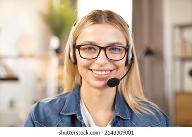 Close Up Of Pretty Young Blond Woman Wearing Headset And Denim Shirt, Smiling On Camera. Professional Female Worker In Casual Wear, Eyeglasses And Headset, Smiling Cheerfully At Camera