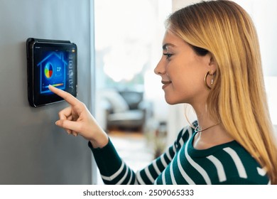 Close up of pretty young woman using the home automation system on digital tablet to regulate the temperature. - Powered by Shutterstock