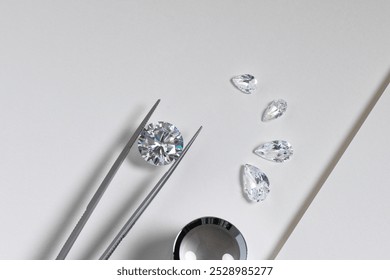 Close up of the process of evaluating natural diamonds using jeweller's tools. Workshop shows diamonds of various cuts and sizes.