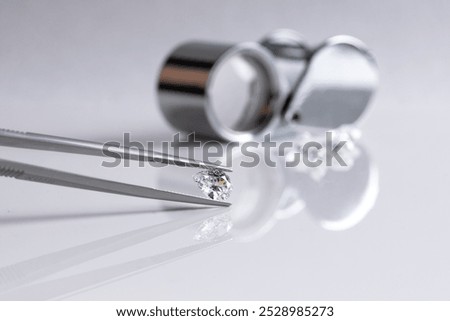 Close up of the process of evaluating natural diamonds using jeweller's tools. Workshop shows diamonds of various cuts and sizes.