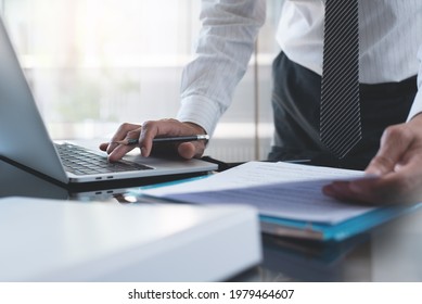 Close Up Of Professional Businessman Working At His Office With Documents. Business Man Proofing Business Report And Working On Laptop Computer On Office Table. Lawyer Reviewing Official Document