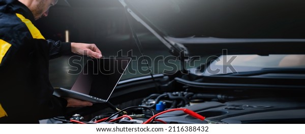 Close up of\
professional car mechanic working in auto repair service.\
Automobile computer diagnostic\
concept.