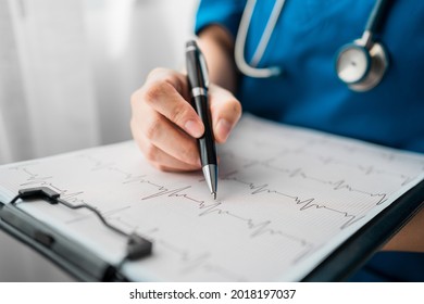 Close up of professional doctor reading and recording cardio diagram graph reports of a patient, Exercise Stress Test (EKG) Check Reports, medical health care concept.