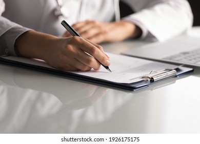 Close up professional female doctor wearing uniform taking notes in journal, physician therapist practitioner filling medical documents, clipboard, patient form, illness history, prescription - Shutterstock ID 1926175175