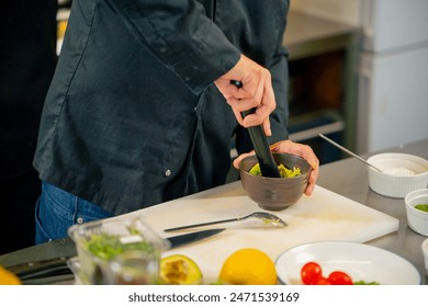 close up in a professional kitchen chef in a black jacket prepares avocado for toast with salmon - Powered by Shutterstock