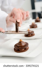 Close Up Of Professional Pastry Cook Hands Preparing Chocolate Dessert In Restaurant Kitchen