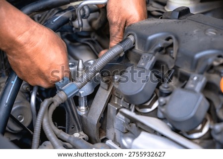 Close up professional unknown mechanic installing new rubber engine mount to car chassis in auto repair shop