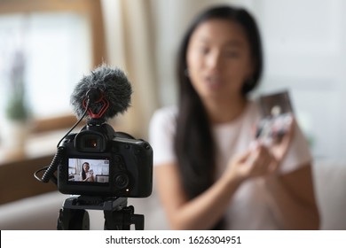 Close up of professional video camera shooting young Asian beauty blogger make unpacking product at home, camcorder device record millennial influencer or vlogger broadcast advertising content