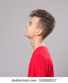 Close Up Profile Emotional Portrait Of Caucasian Teen Boy. Handsome Smiling Guy. Funny Cut Teenager On Gray Background. Child Looking Away.