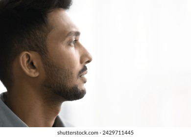 Close up profile face view of pensive Indian man with attractive appearance, well-groomed beard looks into distance posing on white grey copy space background for your text. Thoughts, memories, quotes - Powered by Shutterstock